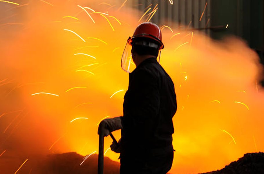 MTP crew member in PPE beside hot slag sparks